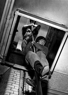 Firefighters slide down the slippery pole to a waiting engine. (1948)