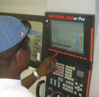 tech Kevin Green programming the controller of the Mazak machining center to fabricate a part.