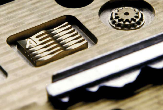 demo Demonstration piece made on an Atometric G4-ULTRA machining center. For scale, part of a key is shown. (Photo courtesy of Atometric, Inc.)